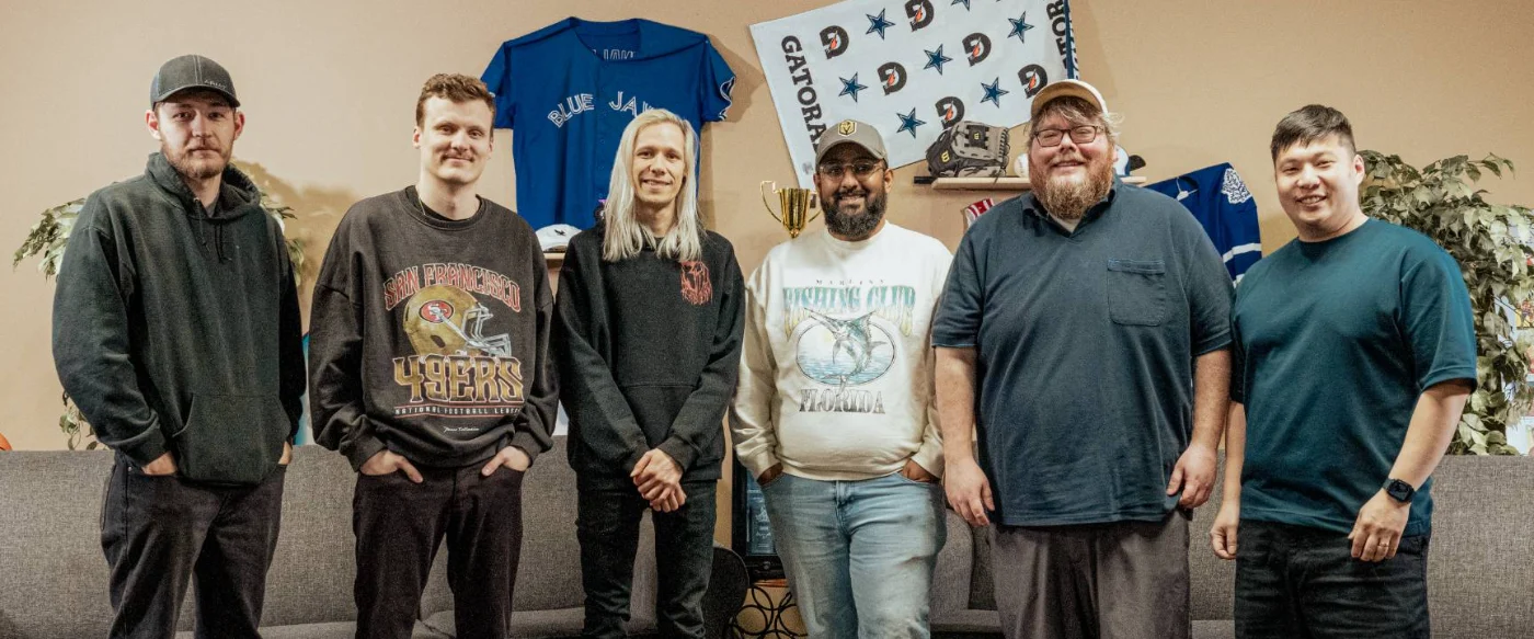 Six people standing in a lounge decorated with sports jerseys: the team that became Chalked Fantasy, in Toronto
